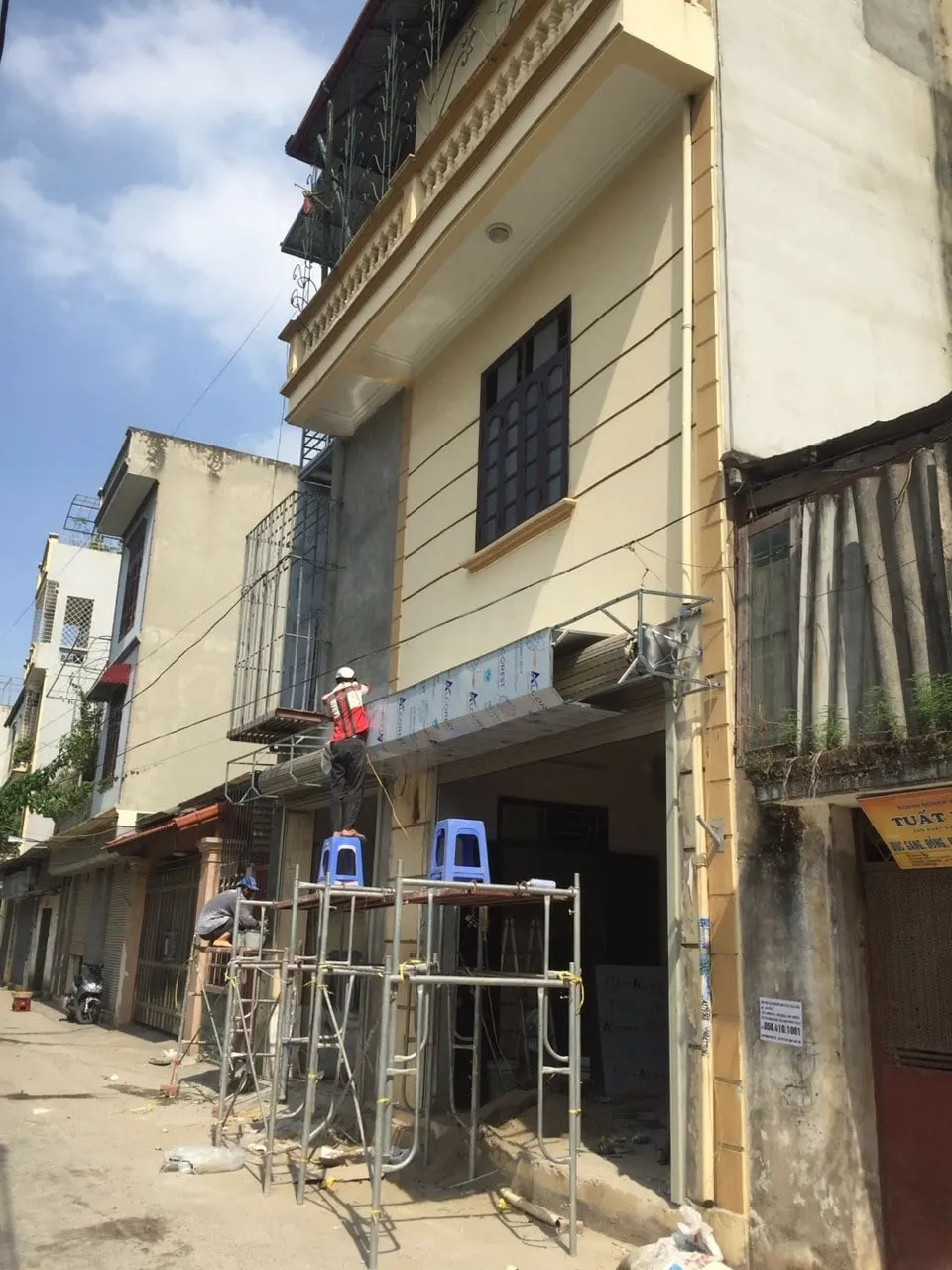 Hình ảnh nhân viên kỹ thuật đang lắp đặt hộp alu màu trắng