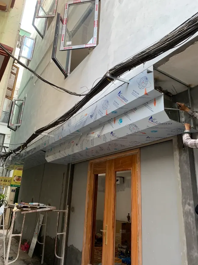 Hình ảnh cửa bên hông bên phải ngôi nhà lắp đặt lô cuốn bên ngoài có hộp kỹ thuật